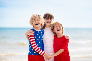 Fototapeta na wymiar Kids with American flag on beach. 4th of July.