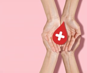 hands holding red blood drop, donor day concept