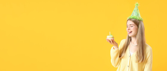 Happy young woman with birthday cake on yellow background with space for text