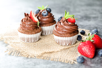 Chocolate cupcakes. Freshly baked muffins with fresh berries