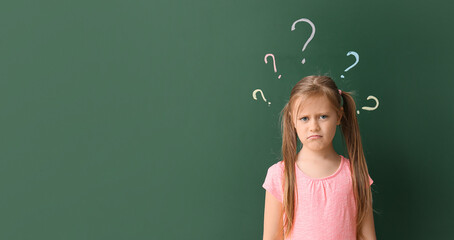 Sad little schoolgirl near blackboard with written question marks. Banner for design