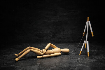 Creative composition with wooden mannequin and cigarettes on dark background. Stop smoking concept