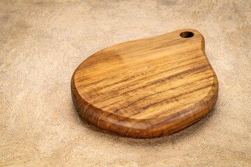 mini wooden cutting board with a handle on textured bark paper