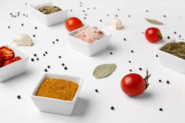 Composition with bowls of fresh spices and vegetables on light background