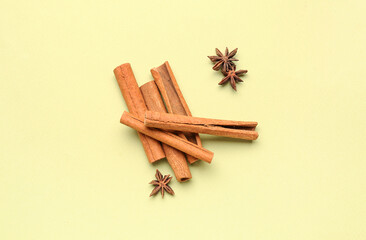 Cinnamon sticks with anise stars on color background