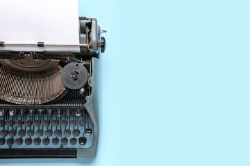 Vintage typewriter with blank paper sheet on blue background