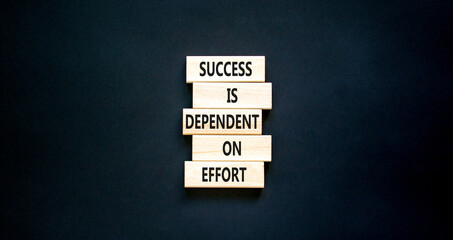 Success and effort symbol. Concept words Success is dependent on effort on wooden block. Beautiful black table black background. Business success and effort concept. Copy space.