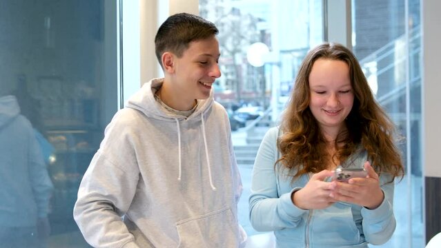 game teenagers girl rips phone out ofhands of guy wants to change something to write to send He takes back she tries to hit him to swing at boy children near window