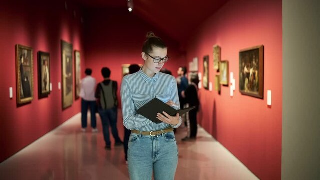women in the museum looks at art exhibitions.