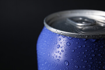 Lilac can of fresh soda with water drops on dark background, closeup