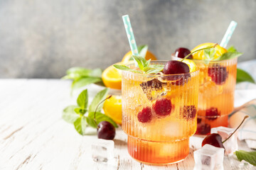 Fresh summer drink. Iced refreshment drink orange cherry cola lemonade or mojito cocktail in glass...