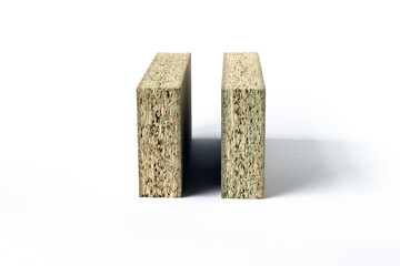 Image of two pieces of particle board standing on edge on a white background. Pressed sawdust.