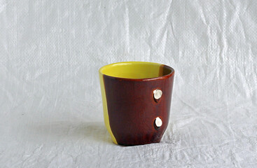 Image of a yellow-brown cup with a broken handle.