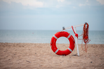 Life preserver on sandy beach. lifebuoy on the seashore. storm warning, sailing in dangerous...
