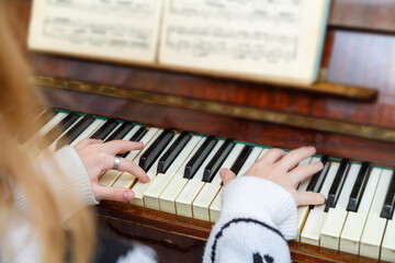 The girl learns to play the piano at the lessons at the music school.