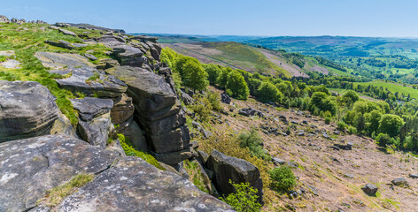 A view down the boulder strewn slopes of the Stanage Edge escarpment in the Peak District, UK in summertime