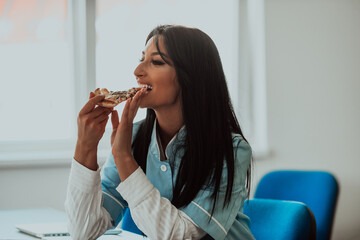 A nurse taking a break from work in the medical office, enjoys a slice of pizza, finding a moment...