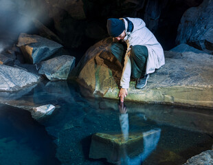 Teenager girl in Grjótagjá cave in Iceland