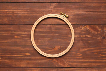 Embroidery hoops on brown wooden background