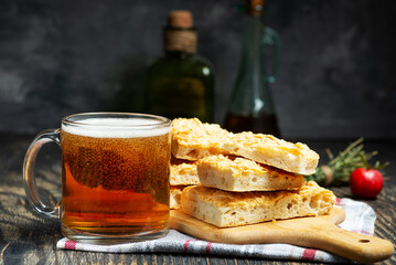 slices of fresh italian focaccho and a mug of beer on a wooden table close-up.