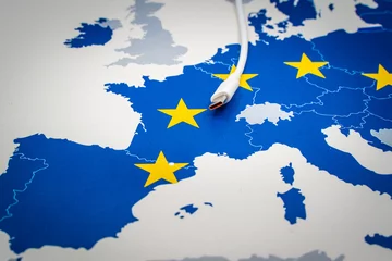 Rolgordijnen USB-C cable over an european map with the EU flag. © tanaonte