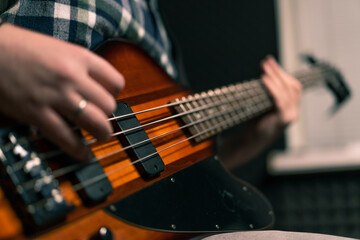 rock performer with electric guitar in recording studio recording playing own track creating song...