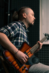 Obraz premium rock performer with electric guitar in recording studio recording playing own track musical instrument strings melody