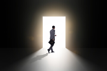 Obraz premium Businessman entering backlit door in escape concept