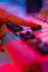 professional recording studio sound engineer finger adjusts sound volume level on mixer console...