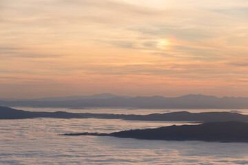 Mist and fog between valley and layers of mountains and hills at sunset, in Umbria Italy - 610759023