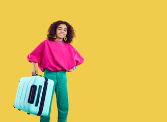 African American millennial girl in stylish clothes isolated on yellow studio background carry...