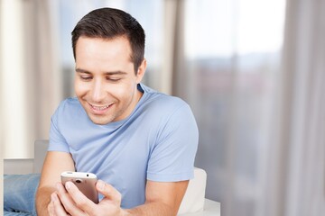 Young happy man holding smartphone