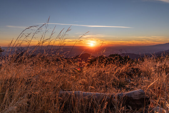 sunset over a field with mountains