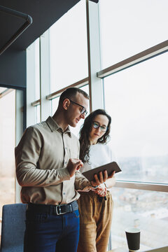 Young Male And Female Colleagues Work In A Spacious Office. Successful People Are Working On A New Business Project. Collective Work In The Office