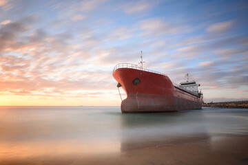 A run ashore ship in the port of Ashdod during a storm in 2020 during the sunset with soft clouds 