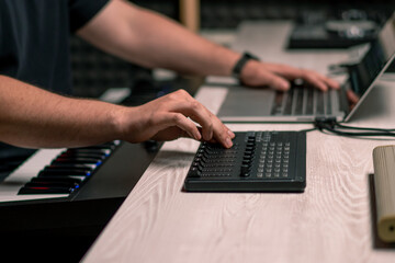 professional recording studio sound engineer with finger adjusts volume level on mixing console...