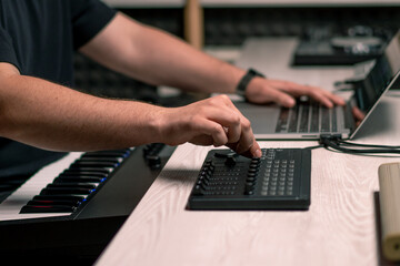 professional recording studio sound engineer with finger adjusts volume level on mixing console...