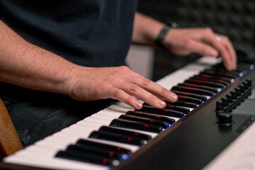 Fototapeta premium professional recording studio sound engineer or music producer musician pressing synthesizer keys
