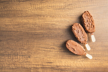 Popsicle, ice cream covered with chocolate on wooden table. Top view.