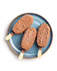 Popsicle, ice cream covered with chocolate on plate isolated on white background.