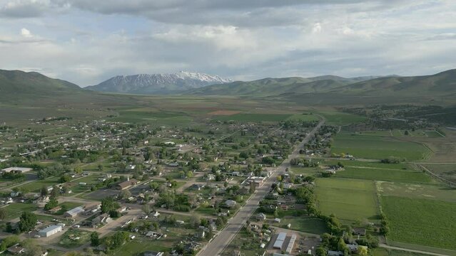 Aerial-Descending view light morning traffic along Main Street thru spall rural mountain valley town 