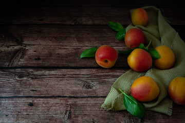 Fresh orange apricots on wooden table with dark background
