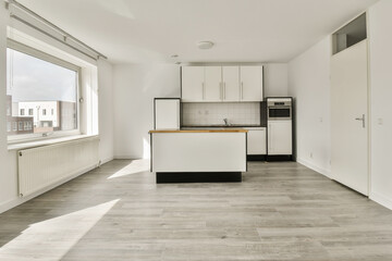 an empty kitchen and dining area in a house with white walls, wood flooring and large windows looking out onto the street
