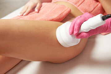 Beauty treatment on hip with a ultrasonic cavitation device - obrazy, fototapety, plakaty