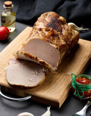Baked piece of pork balyk on the table with spices. Tenderloin cut into pieces