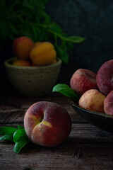 Fresh peaches on wooden table with dark background