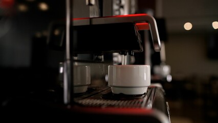 Close-up of pouring espresso. Professional coffee making. The coffee machine is pouring coffee.