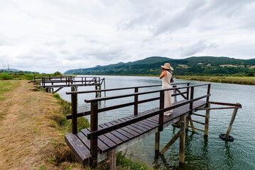 Woman on wooden pier of Murueta in Urdaibai biosphere reserve, Biscay, Basque Country, Spain