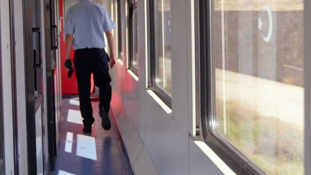 4K footage of conductor walking on moving train corridor in daylight stock video.