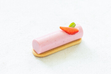 Vegan Strawberry cream dessert bar on cookie. Decorated with fresh strawberry slice. White background